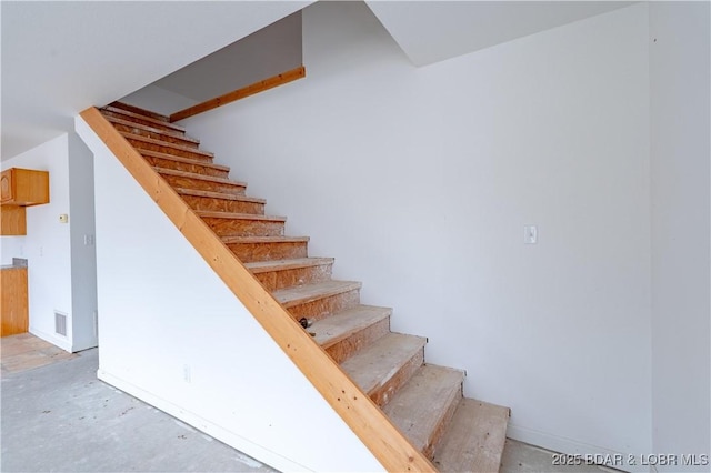 stairway featuring concrete flooring