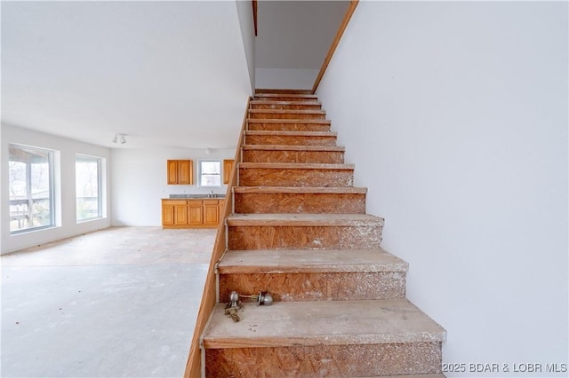 stairway featuring concrete flooring and sink