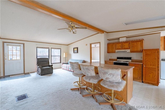 kitchen featuring crown molding, range with electric stovetop, lofted ceiling with beams, a kitchen bar, and light carpet