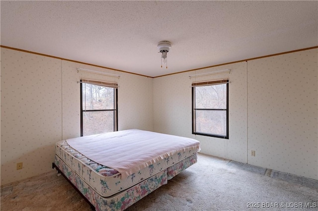 carpeted bedroom with crown molding and a textured ceiling