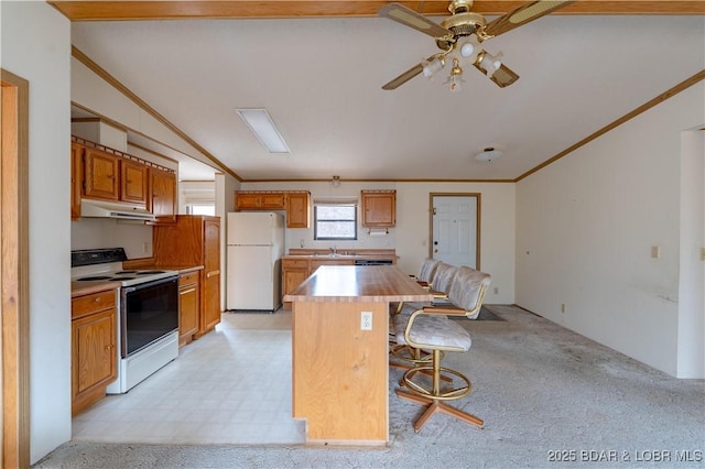 kitchen featuring ornamental molding, a kitchen island, a kitchen bar, and white appliances