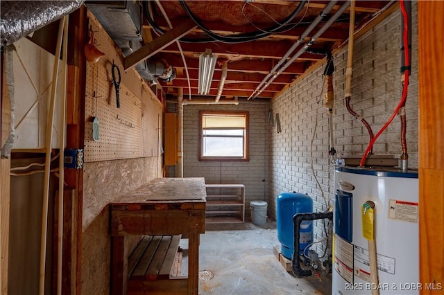 basement featuring water heater and brick wall