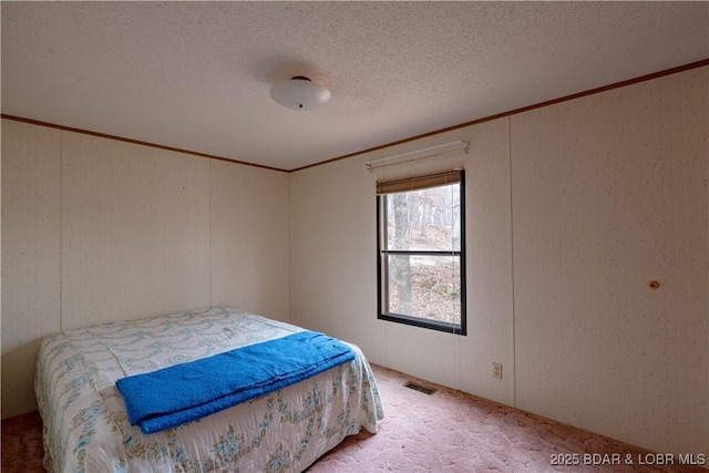 carpeted bedroom featuring ornamental molding and a textured ceiling