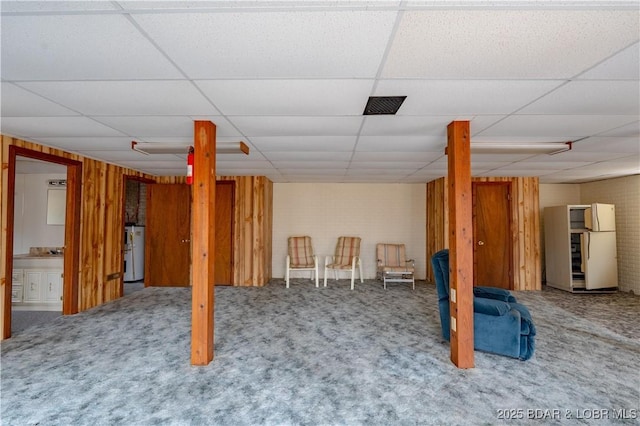 basement with a drop ceiling and carpet floors