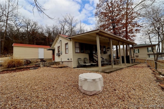 back of house with a patio and a shed