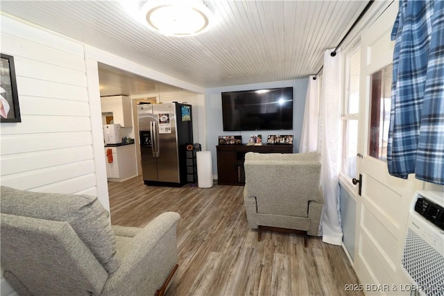 living room with wood ceiling, hardwood / wood-style flooring, and wooden walls