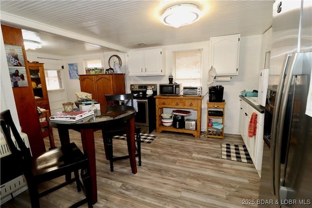 kitchen featuring white cabinetry, appliances with stainless steel finishes, and light hardwood / wood-style flooring