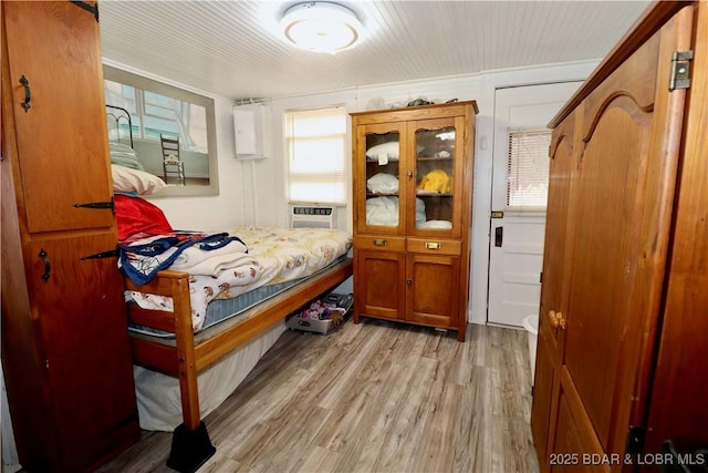 bedroom with cooling unit and light wood-type flooring