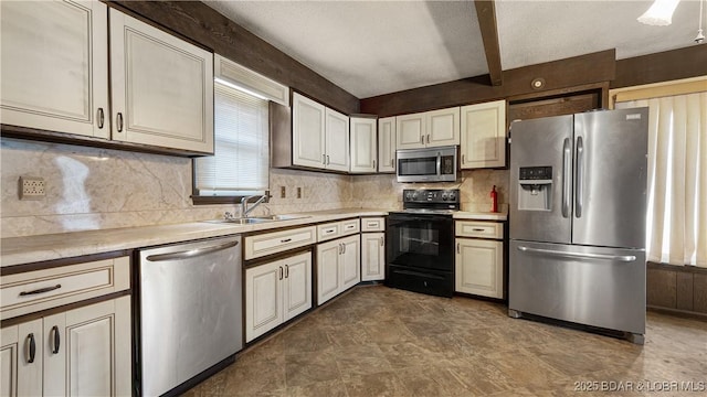 kitchen featuring appliances with stainless steel finishes, beam ceiling, sink, and decorative backsplash