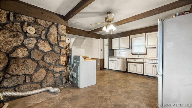 kitchen featuring sink, appliances with stainless steel finishes, white cabinetry, beam ceiling, and washer / clothes dryer