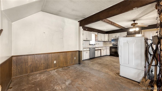 kitchen featuring appliances with stainless steel finishes, wooden walls, white cabinetry, ceiling fan, and a textured ceiling