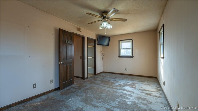 unfurnished bedroom with ceiling fan and a textured ceiling