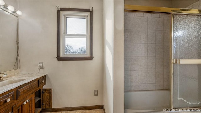 bathroom with vanity and combined bath / shower with glass door