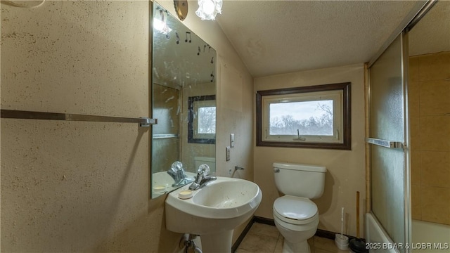 full bathroom with toilet, sink, shower / bath combination with glass door, a textured ceiling, and tile patterned flooring