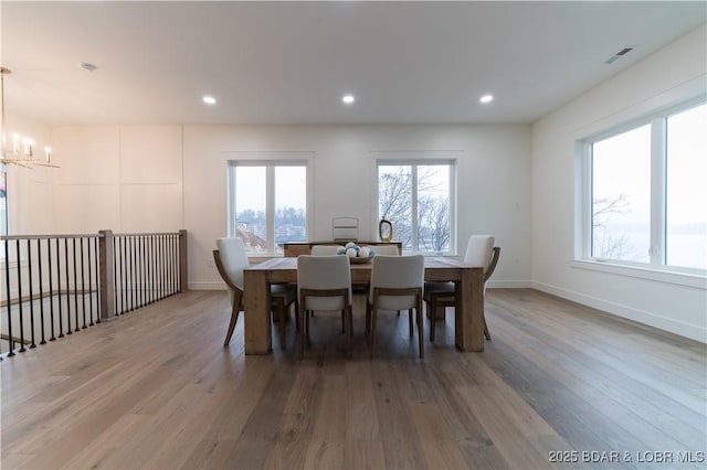 dining space with hardwood / wood-style flooring and an inviting chandelier