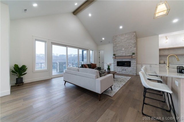 living room featuring beamed ceiling, a fireplace, dark hardwood / wood-style flooring, and high vaulted ceiling