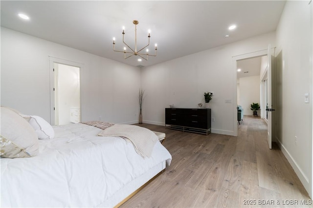 bedroom with light hardwood / wood-style floors and a notable chandelier