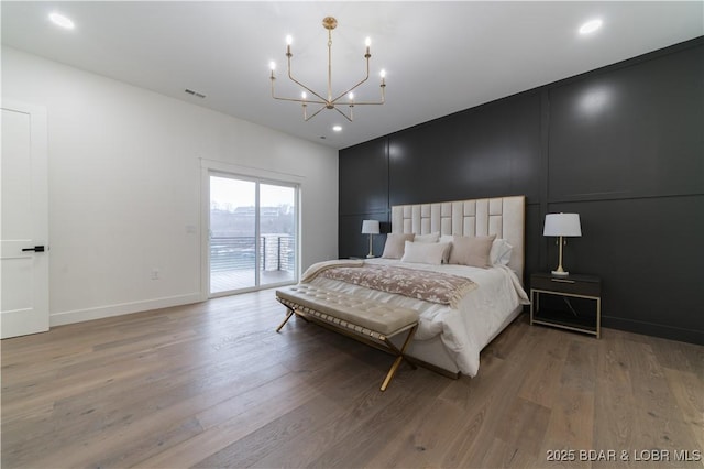 bedroom featuring access to exterior, a chandelier, and light wood-type flooring