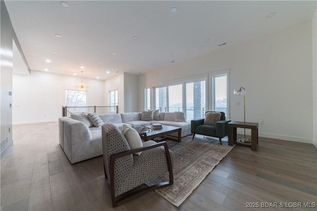 living room featuring a water view, wood-type flooring, an inviting chandelier, and plenty of natural light