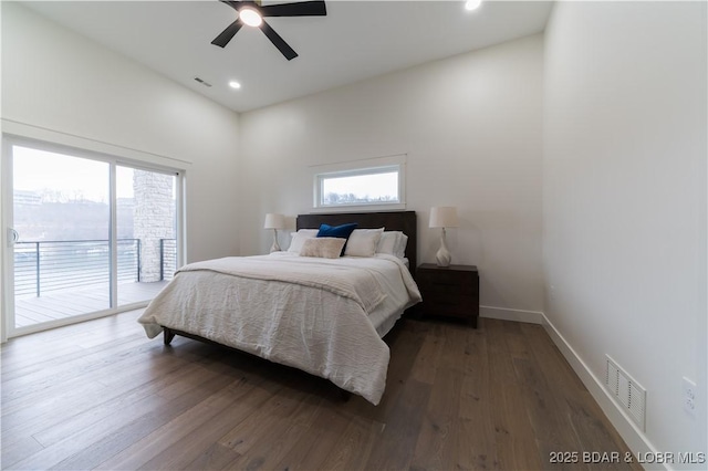 bedroom featuring multiple windows, access to exterior, and dark hardwood / wood-style flooring