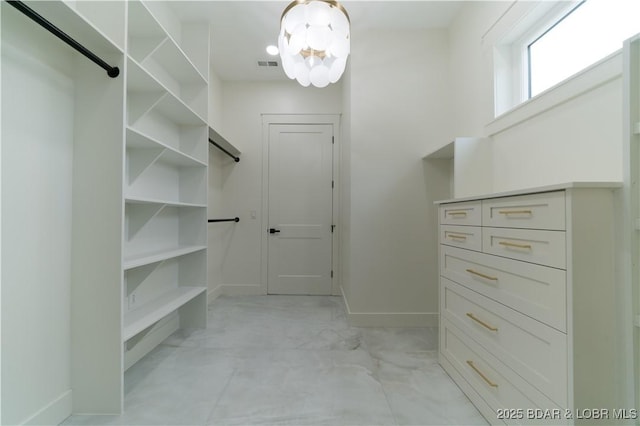 walk in closet featuring a chandelier