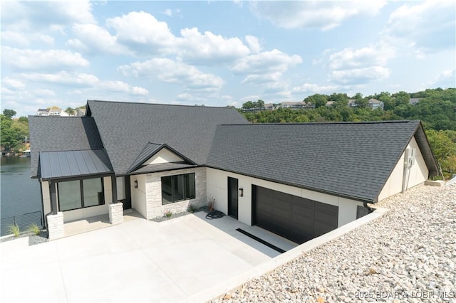 view of front of property with a garage and a water view