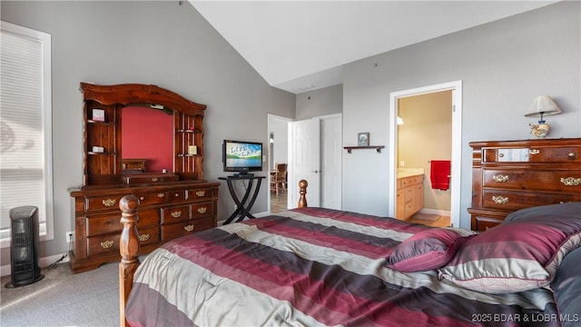 bedroom with light carpet, vaulted ceiling, and ensuite bathroom