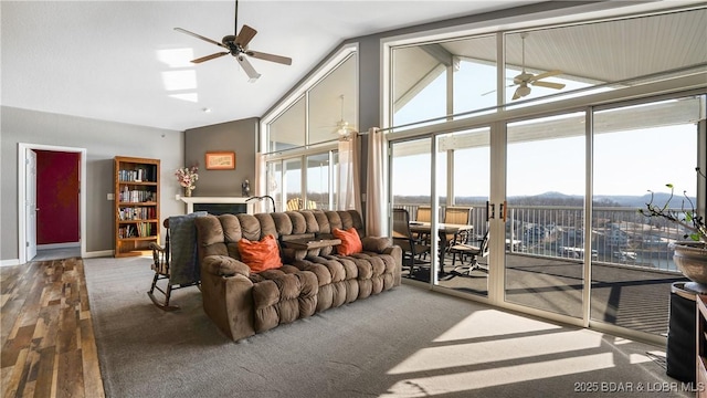 living room with baseboards, a ceiling fan, high vaulted ceiling, and wood finished floors