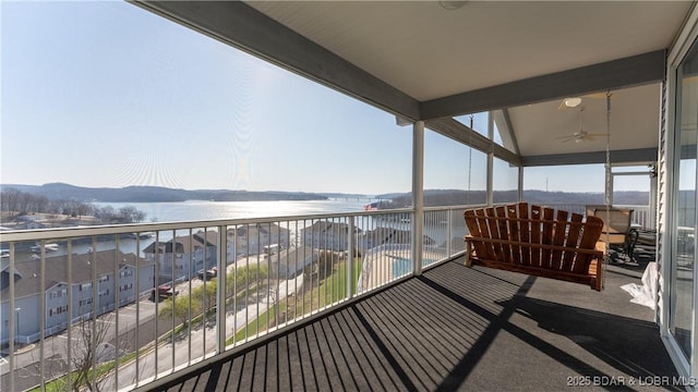 balcony with a water and mountain view and ceiling fan