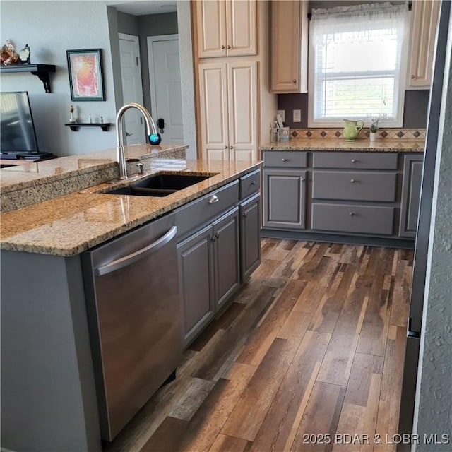 kitchen with dishwasher, sink, gray cabinetry, light stone counters, and dark wood-type flooring