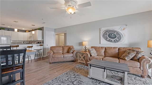 living room with ceiling fan and light wood-type flooring