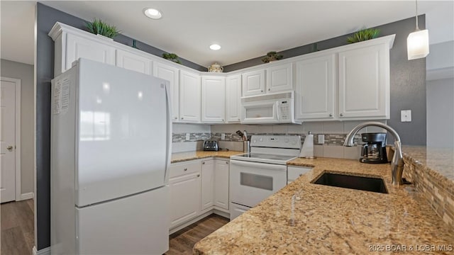 kitchen featuring pendant lighting, white appliances, light stone countertops, and white cabinets