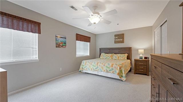 carpeted bedroom with ceiling fan and a closet