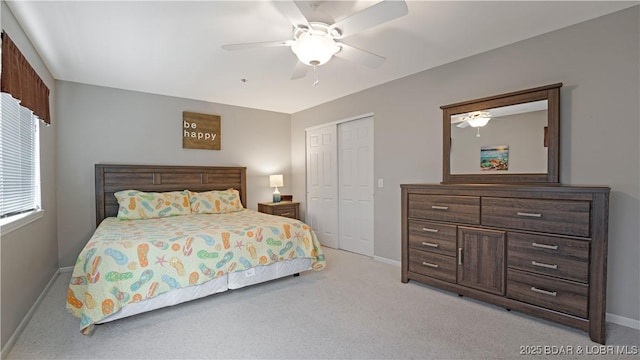 bedroom with ceiling fan, light colored carpet, and a closet