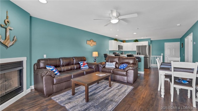 living room featuring ceiling fan and dark hardwood / wood-style floors