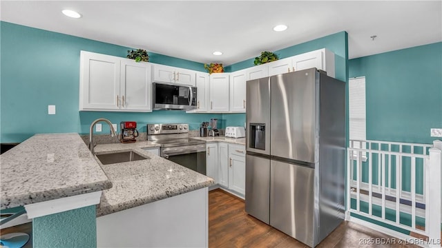 kitchen with white cabinetry, appliances with stainless steel finishes, and kitchen peninsula