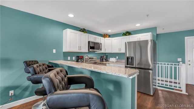 kitchen featuring white cabinetry, stainless steel appliances, and kitchen peninsula