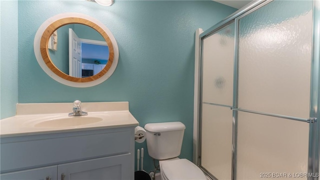 bathroom featuring vanity, toilet, and an enclosed shower