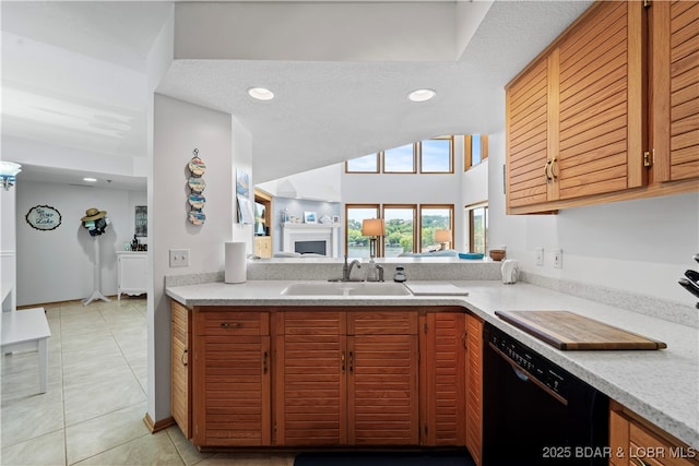 kitchen featuring dishwasher, sink, a textured ceiling, and light tile patterned floors