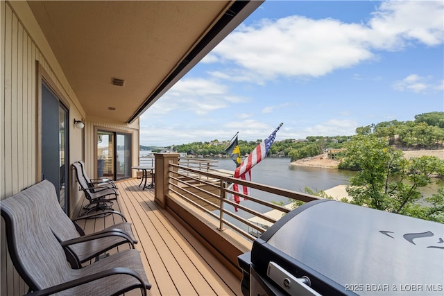 balcony featuring a water view and a grill