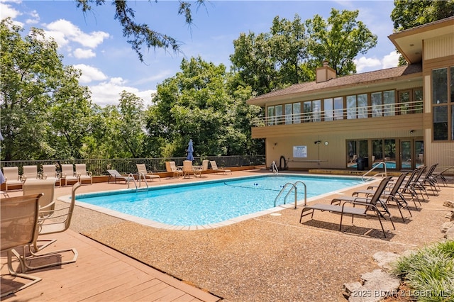 community pool featuring fence and a patio area