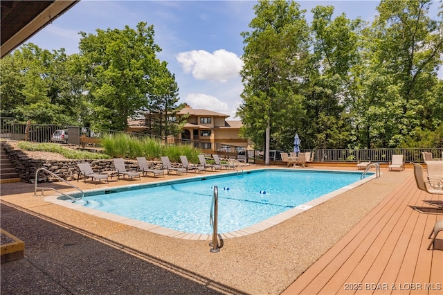 community pool with fence and a patio