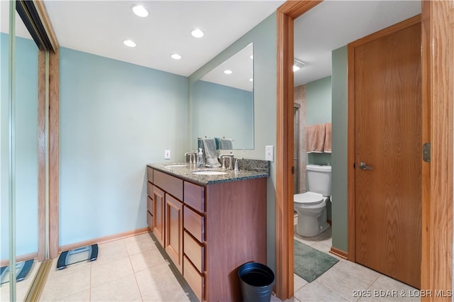 bathroom with tile patterned flooring, vanity, and toilet