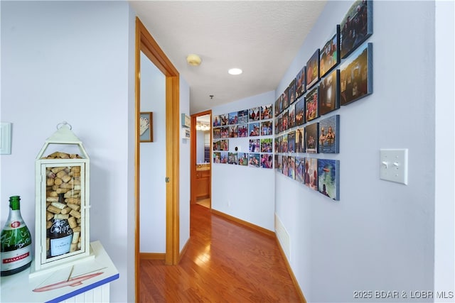 hall featuring hardwood / wood-style floors and a textured ceiling