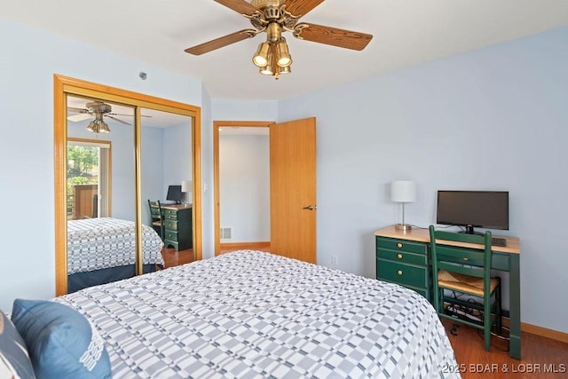 bedroom with wood finished floors, a closet, a ceiling fan, and baseboards