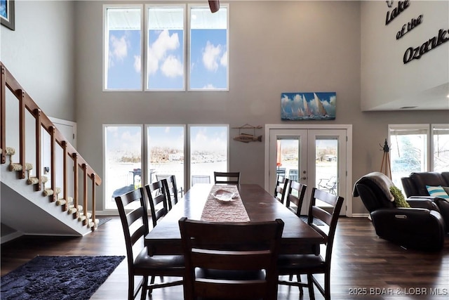 dining space with a high ceiling, dark hardwood / wood-style floors, and french doors