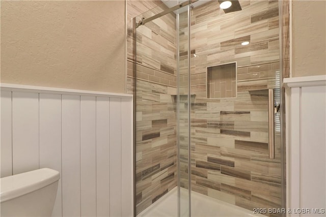 bathroom featuring toilet and an enclosed shower