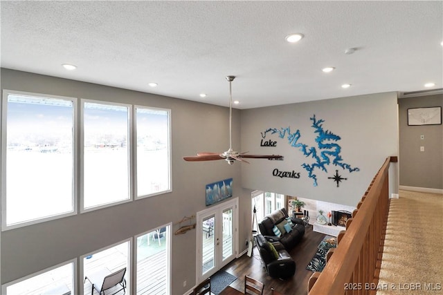 living room with french doors, carpet floors, and a textured ceiling