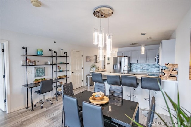 dining space with sink and light hardwood / wood-style floors