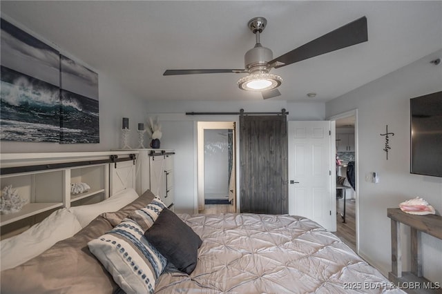 bedroom featuring a barn door and ceiling fan